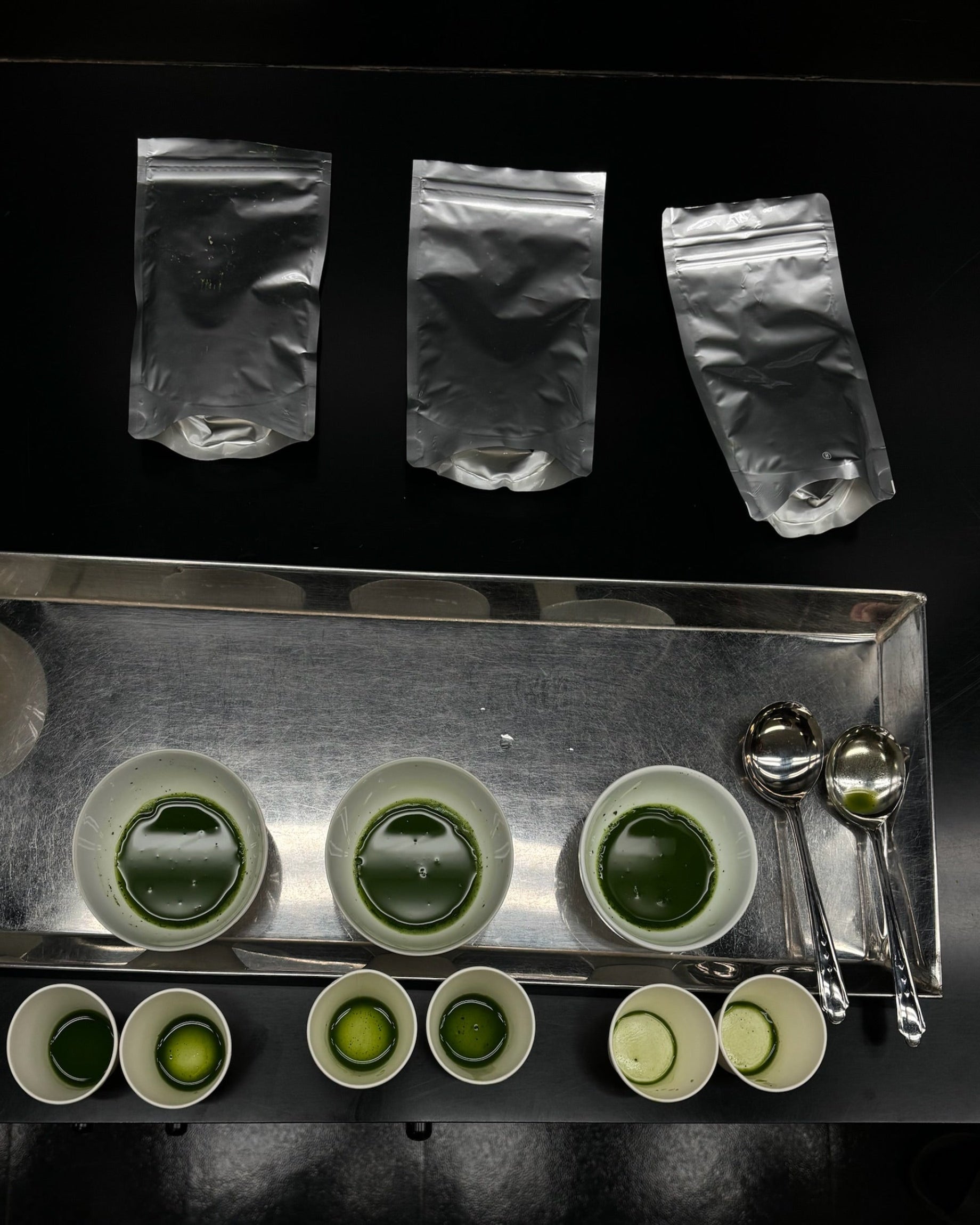 Tray with small bowls of matcha, spoons.